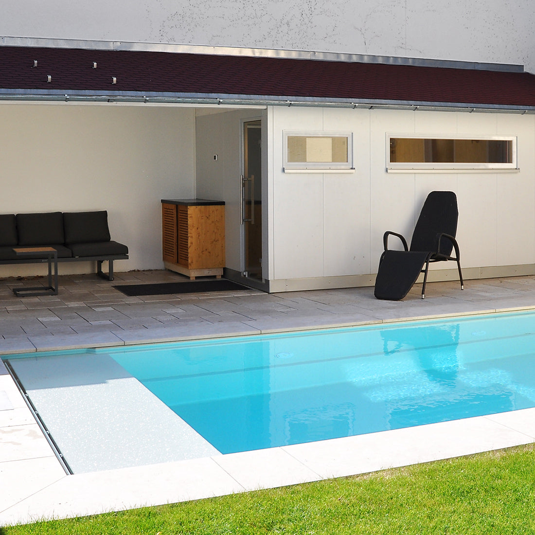 Außensauna mit angrenzendem Technikaum, Außenverkleidung in nord. Fichte mit Anstrich in Lichtgrau, mit Ruhebereich und Pool