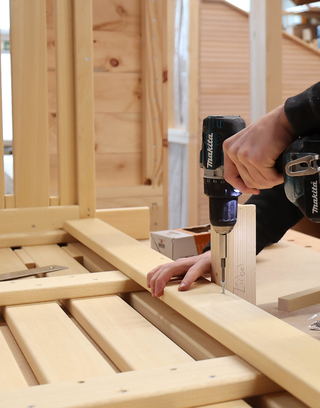 Schreinerwerkstatt, Schreiner beim Schrauben an Saunabank, bewirb dich jetzt