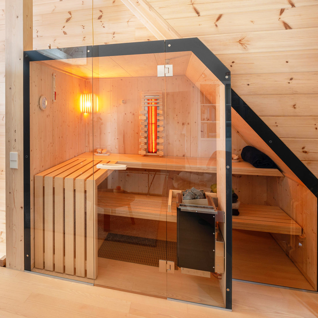 Individueller Einbau Sauna in Dachschräge, mit großzügiger Glasfront und Infrarotsitzplatz